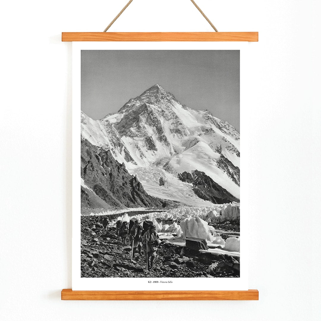 Black and white photo by Vittorio Sella of mountaineers trekking toward K2 over the Godwin Austen glacier titled Le pic K2 vue prise du glacier Godwin Austen, with wooden magnetic frame on white background