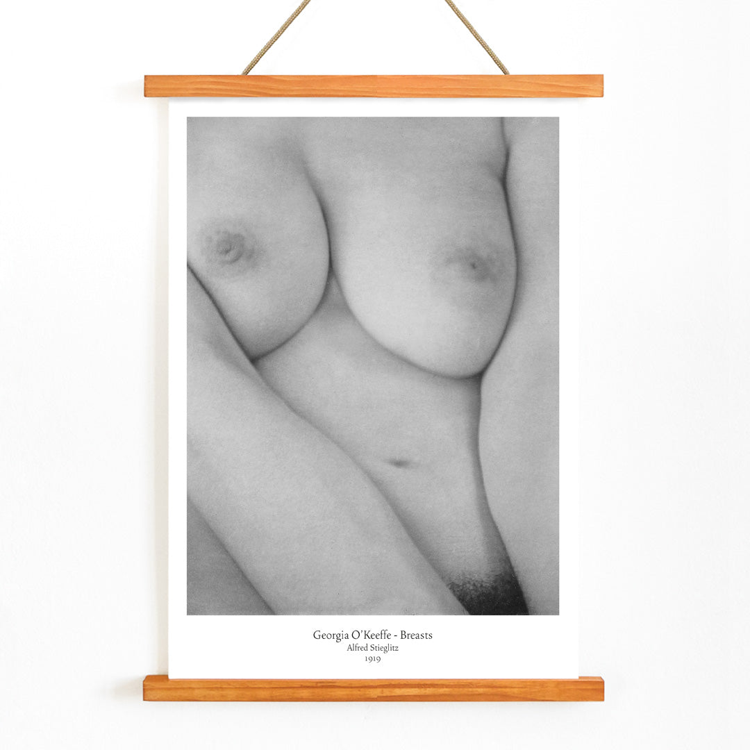 Black and white photograph poster of Georgia O Keeffe breasts by Alfred Stieglitz featuring a close up nude female torso, with wooden magnetic frame on white background