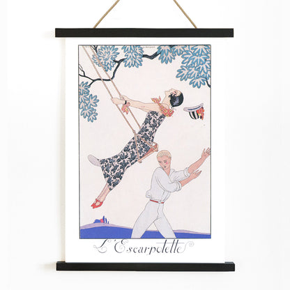 Art Deco poster of a woman on a swing with a man beneath under a tree from LEscarpotette by George Barbier, with wooden magnetic frame on white background