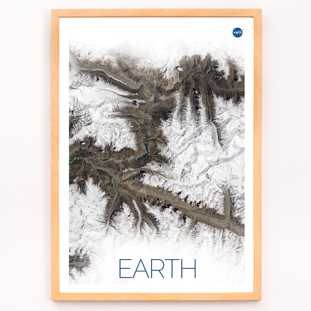 Stunning NASA satellite image of Earth showing snowy mountain ranges and rugged terrain high resolution poster, framed and displayed in modern living room decor
