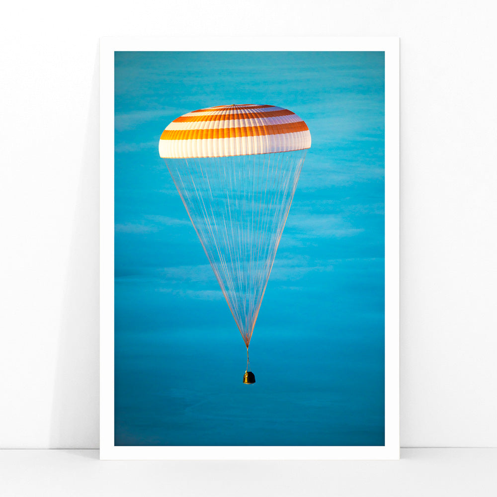 Soyuz TMA-14M spacecraft descending with parachute against blue sky NASA Expedition 42 landing poster artwork, framed and displayed in modern living room decor