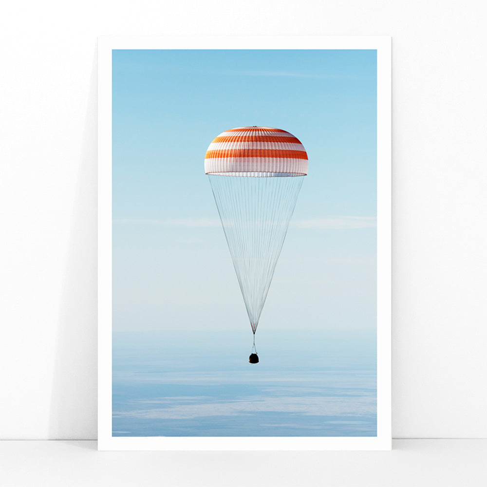 Soyuz MS-02 spacecraft descending with parachute over Kazakhstan NASA poster titled The Soyuz MS-02 spacecraft lands, framed and displayed in modern living room decor