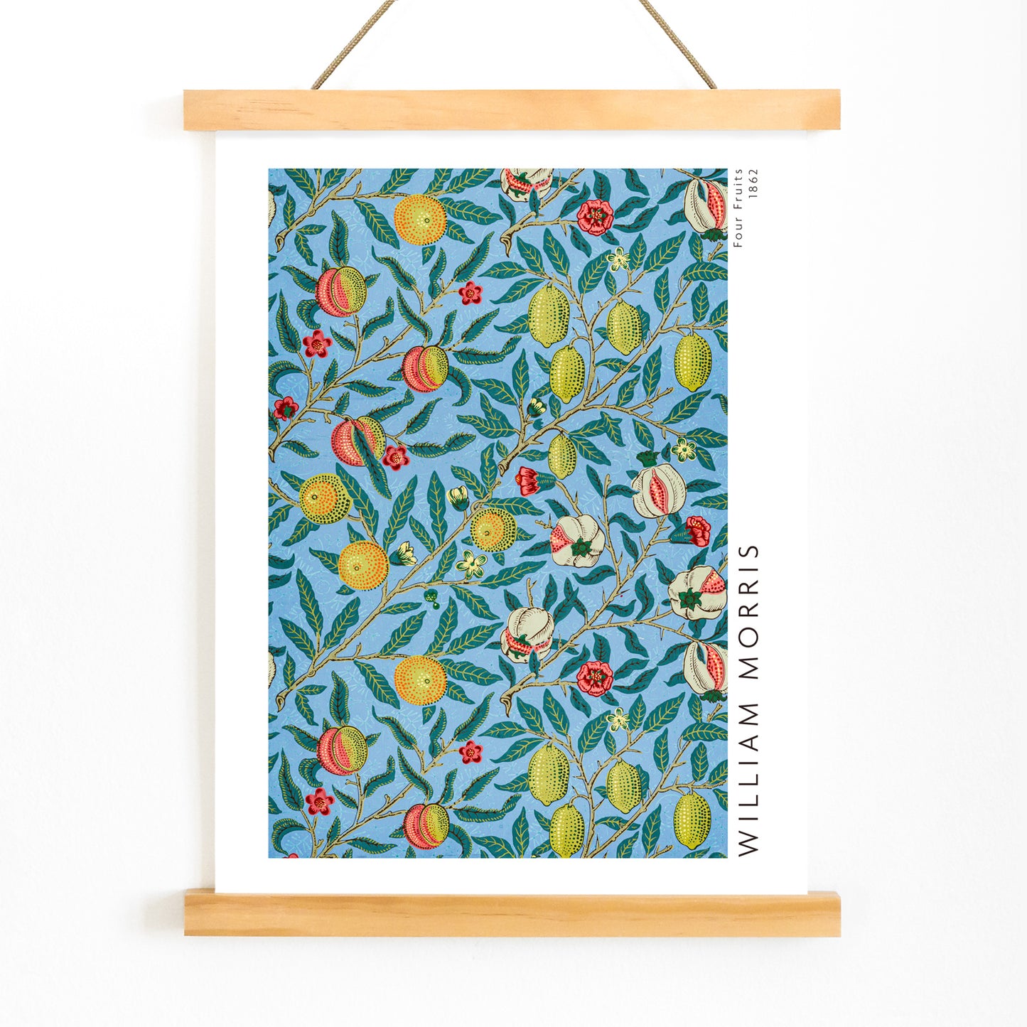 Colorful botanical wallpaper and poster featuring fruits and leaves from Four Fruits pattern by William Morris on blue background for wall decor, with wooden magnetic frame on white background