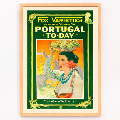 Colorful vintage poster of Portugal Today featuring a woman in traditional attire carrying grapes and fruit on her head with vibrant backdrop by William Fox and Anonymous, framed and displayed in modern living room decor