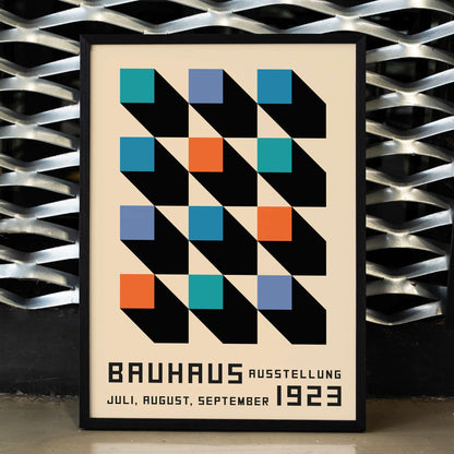 Bauhaus Poster inspired by the Weimar Exhibition with geometric patterns bold colors by Joost Schmidt in black blue orange and teal squares, framed and displayed in home decor