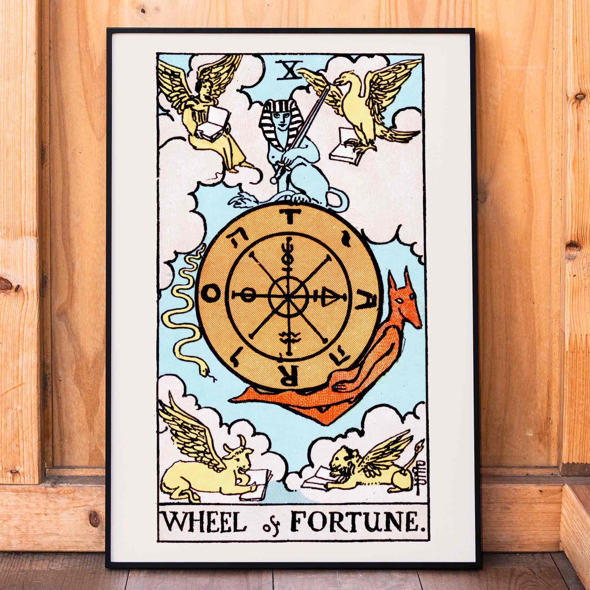 Tarot The Wheel Of Fortune by Rider Waite featuring a mystical wheel surrounded by mythical creatures poster and card artwork, framed and displayed in home decor