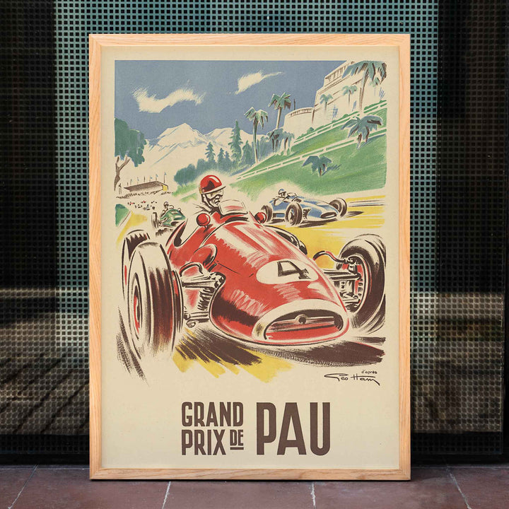 Georges Hamel Grand Prix de Pau poster with red racing car on a sunlit circuit near green hills and mountain castle, framed and displayed in home decor