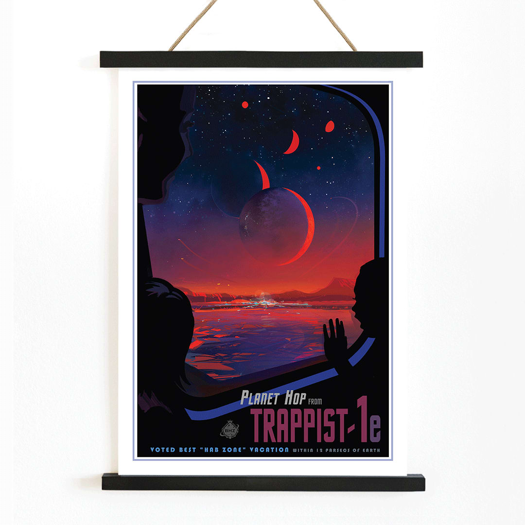 Colorful sci fi poster of TRAPPIST-1e by NASA showing vibrant alien landscape with planets glowing sky and silhouetted figures viewed from a window, with wooden magnetic frame on white background