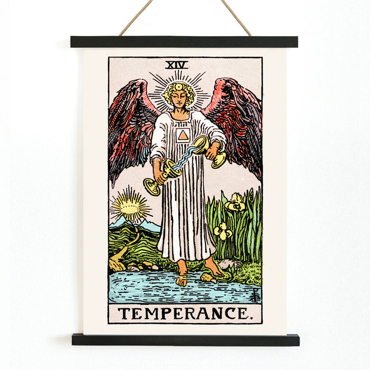 Temperance tarot card by Rider Waite featuring an angel with wings pouring liquid between two cups illustration and poster, with wooden magnetic frame on white background