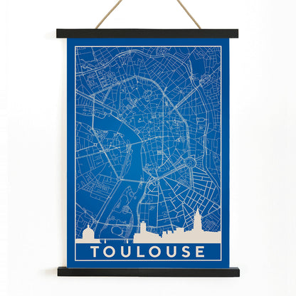 Blue and white minimalist map of Toulouse poster with white building silhouettes at the bottom modern wall art titled Minimalist Toulouse Map, with wooden magnetic frame on white background