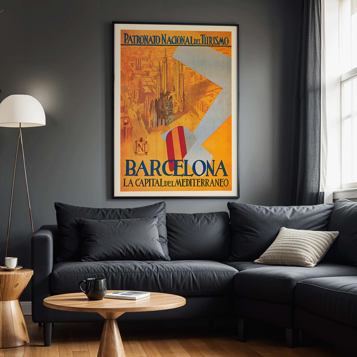 Barcelona La Capital del Mediterraneo poster by Patronato Nacional del Turismo featuring city skyline cathedral cityscape and flying flag, framed and displayed in modern living room decor