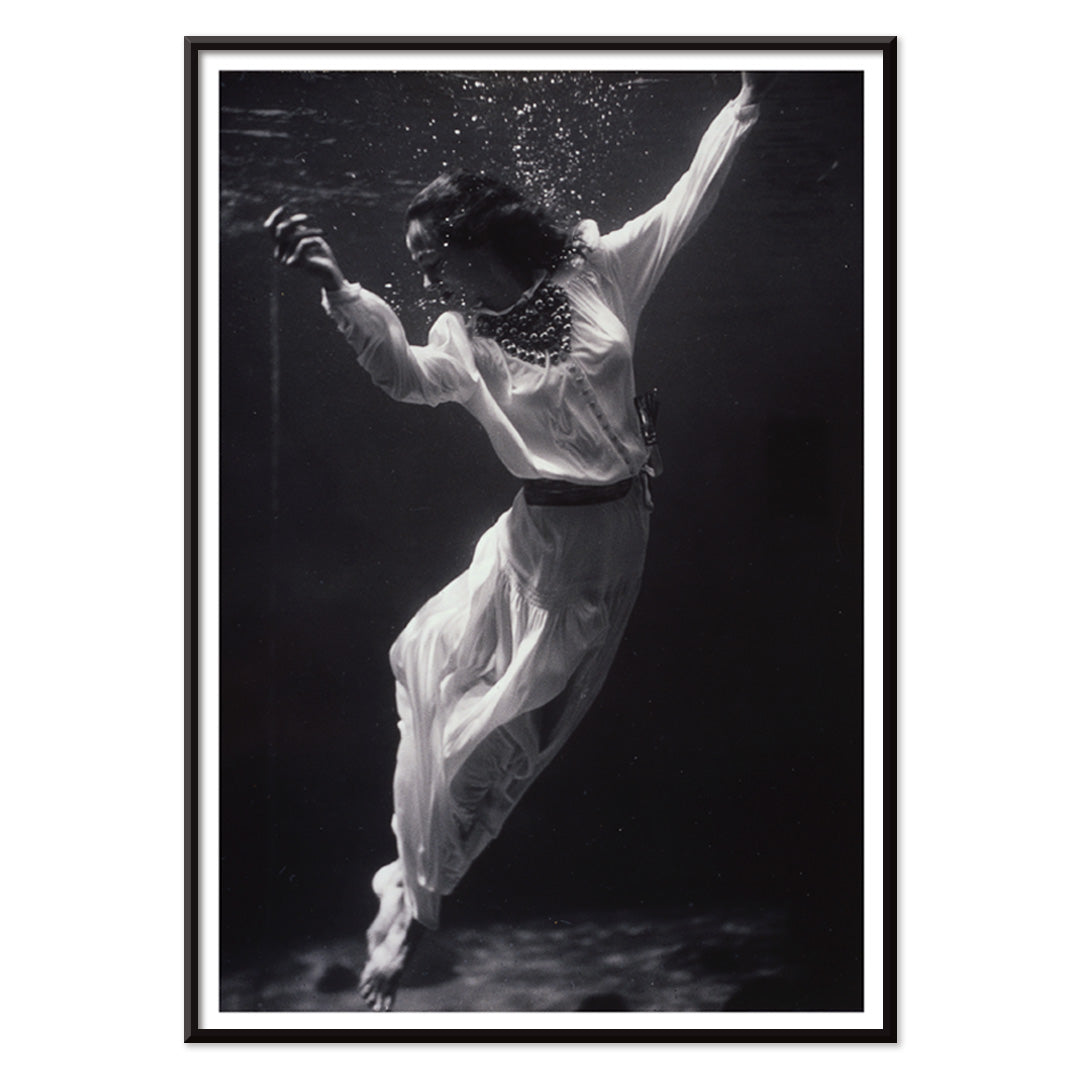 Black and white artwork of a fashion model floating underwater in dolphin tank Marineland Florida by Toni Frissell, with black aluminium frame on white background